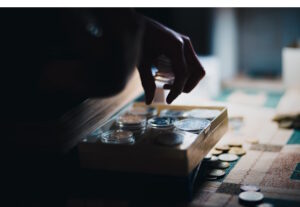 Hand taking coins from small wooden drawer