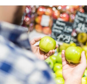 Consumer defensive. Shopper holding two green apples
