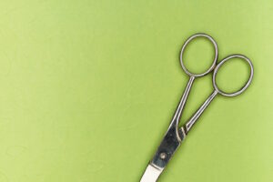Silver scissors on lime green background